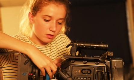 Pupil Bethany Smith changes the lens on a camera during filming
