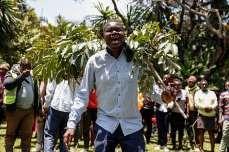 A mourner holding a branch with others lined up behind him