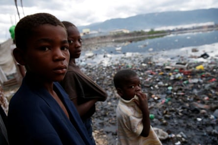 Children stand next to a flooded area in Cité-Soleil, Port-au-Prince.