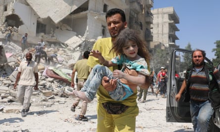 A man carries a wounded child in the Maadi district of eastern Aleppo after regime aircraft reportedly dropped explosive-packed barrel bombs on 27 August 2016.
