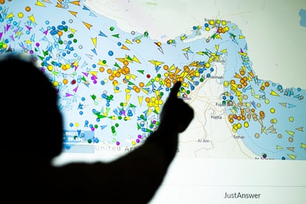 A silhouetted person points at a back-lit map