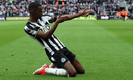 Newcastle United's Alexander Isak celebrates scoring their first goal against Tottenham Hotspur with a knee slide.
