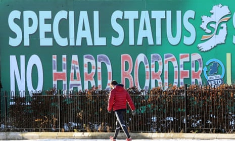A pedestrian walks past a Sinn Féin billboard in west Belfast that calls for a special status for Northern Ireland.