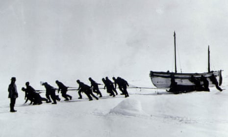 The crew of Endurance hauling the lifeboat James Caird, with Shackleton looking on (left).