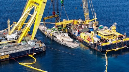 Drone view of floating crane ships lifting the Bayesian from below the water surface.