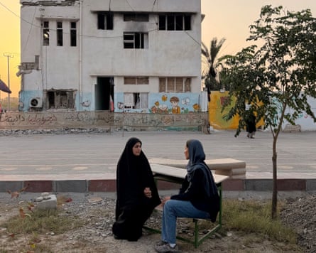 Nawal Al-Maghafi talks to Amaineh Nademi in front of Shajareh Tayyebeh primary school.