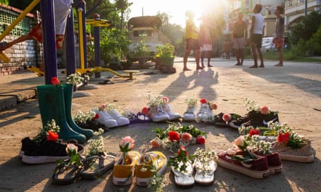 A child playing near shoes displayed with flowers in Yangon’s Insein township, as part of the ‘Marching Shoes Strike’ called on social media to protest against the demonstration against the military coup in Myanmar