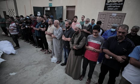 Palestinians pray for those killed in the the latest Israeli bombardments, outside the Al-Aqsa Martyrs Hospital in the city of Deir Al-Balah.