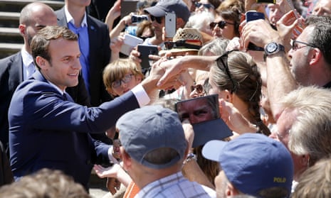 French President Emmanuel Macron shakes hands with the public as he leaves the polling station after casting his vote in the first round of the French elections in Le Touquet-Paris-Plage. 