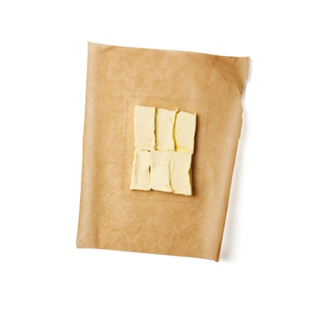 Cut the butter into small, flat tiles. Cut out two rectangles of greaseproof paper, and draw a 15cm x 20cm rectangle in the middle of one. Arrange the tiles of butter in a tight rectangle in the centre of the other piece of paper