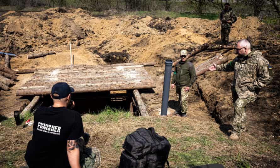 Soldiers sit near new trenches outside the city of Zaporizhzhia