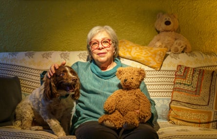 Melinda Rand sitting on a sofa with a dog and her bear, Honey Pot