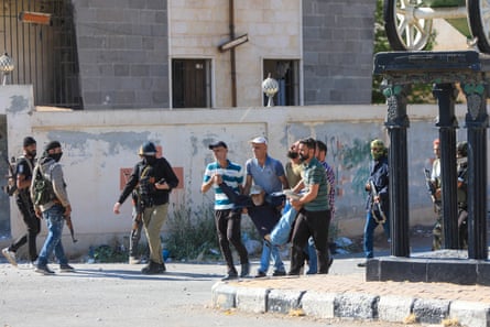 People carry a man wounded during clashes
