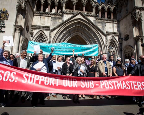 Campaigners outside the Royal Courts of Justice holding a sign reading 'SOS: Support our sub-postmasters'