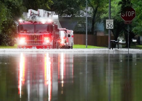 A Houston firetruck makes it way through flood water in North Woodland Hills after severe flooding.