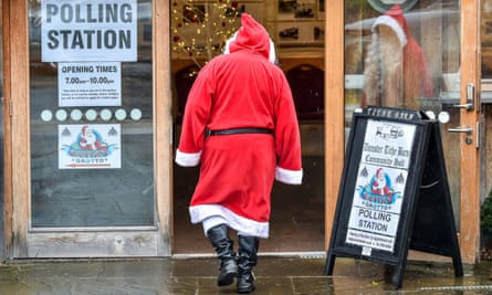 A man dressed as Father Christmas enters his grotto at the Dunster Tithe Barn near Minehead, Somerset, which is being used as a polling station