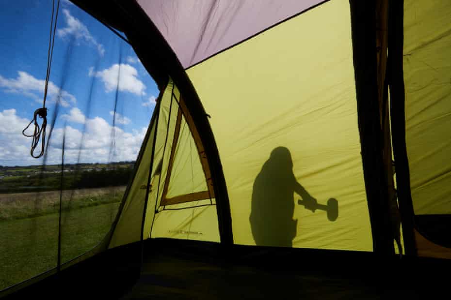 Forty year camping veteran Mick Cooper from Sheffield erecting his inflatable tent shortly after arriving on the site.