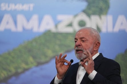 Luiz Inácio Lula da Silva talks in front of a poster of a map and the word ‘amazonia’