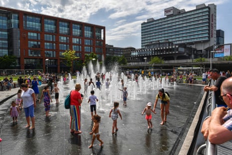 People splash in the fountains in Piccadilly Gardens in central Manchester.