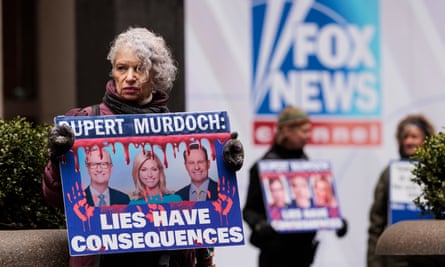 Sandy R, of New York, holds a sign while participating in a protest organized by the group Rise and Resist outside Fox News headquarters in New York on Tuesday.