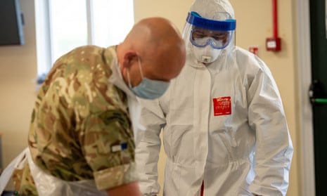 Members of the British army learn how to apply PPE during training to support the Welsh Ambulance Service NHS Trust.