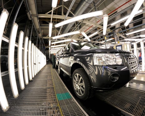 Jaguar Land Rover assembly line at Halewood: a dark grey vehicle is at the front of the image framed by bright lighting.