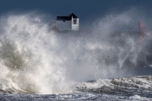 A big wave crashes on a pier in front of a house in western France as storm Bella caused torrential rain and heavy winds in much of France