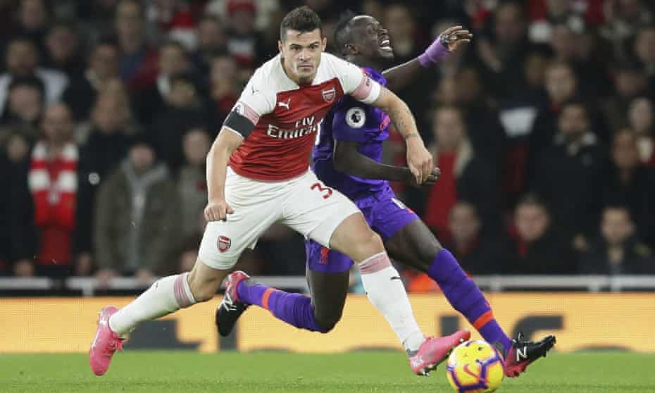 Arsenal’s Granit Xhaka fights for the ball with Liverpool’s Sadio Mané.