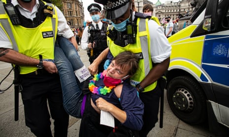 Police officers detain an an Extinction Rebellion activist during a rally in Parliament Square, London.
