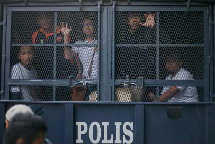 Malaysian protesters are held inside a police vehicle during protests against prime minister Najib Razak, calling on him to step down.