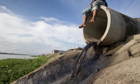 A Bangladeshi man sits on a concrete pipe, as tannery industrial water empties out into the Daleshwari River in Savar, Bangladesh. More than 100 leather tanneries that were forced to relocate because of their massive pollution are now running toxic waste into this river, creating new environmental and health problems for community members and laborers.