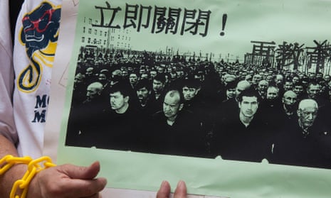 A protester in Hong Kong holds a photo of Uighur prisoners.