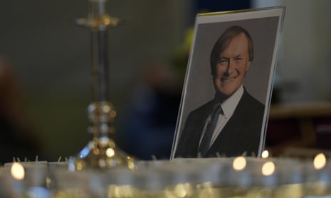 Candles are lit next to a portrait of Sir David Amess during a vigil on Sunday at St Michael’s church in Leigh-on-Sea