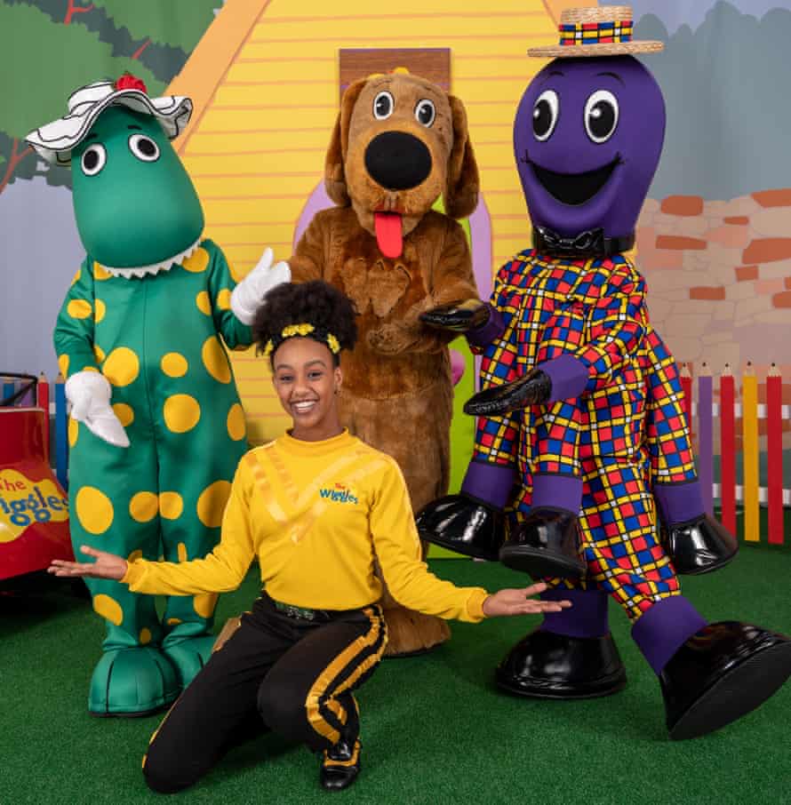 Yellow Wiggle Tsehay Hawkins poses with Dorothy the Dinosaur, Wags the Dog, and Henry the Octopus.