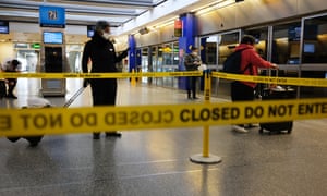 Travelers walk through a mostly empty John F Kennedy airport in New York.