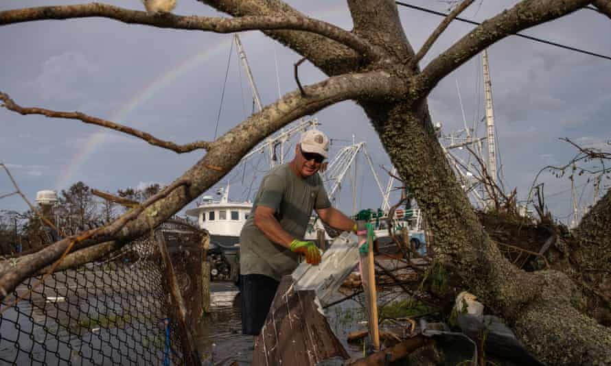 A man clears debris from his yard in the aftermath of Hurricane Ida in Galliano, Louisiana