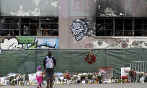 In December 2016, flowers, pictures, signs and candles, are placed at the scene of the Ghost Ship fire.