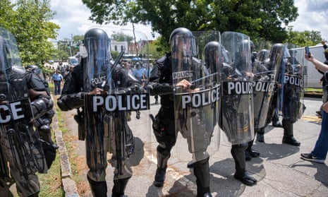 Riot police move protesters after confrontations between protesters and militia members in Stone Mountain, Georgia. 