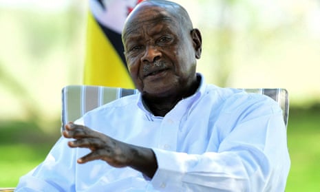 Yoweri Museveni pictured sitting outside, one arm raised.