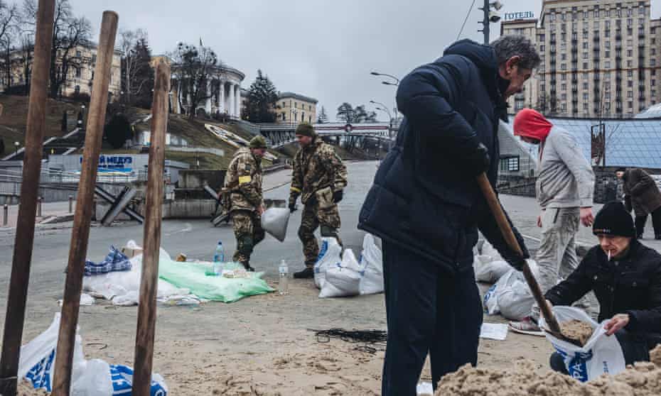 Ukrainian soldiers and volunteers prepare sandbags for barricades in Kyiv on Thursday.