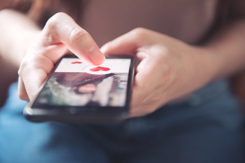 Degetul unei femei apasă pictograma inimii pe ecranul aplicației mobile pentru smartphone. Aplicație de dating online, concept de Ziua Îndrăgostiților.