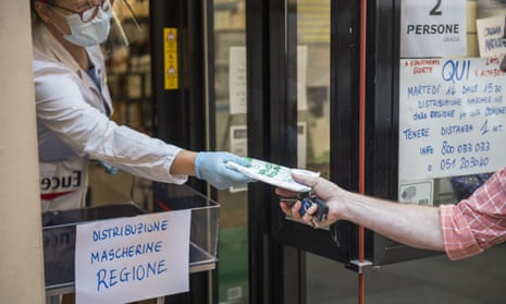 Pharmacists distribute free protective masks in a bid to combat the spread of Covid-19 in Bologna, Italy.