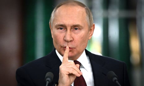 Vladimir Putin gestures silence with a finger to his mouth