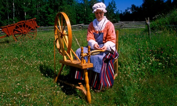 A woman in traditional costume at a spinning wheel.