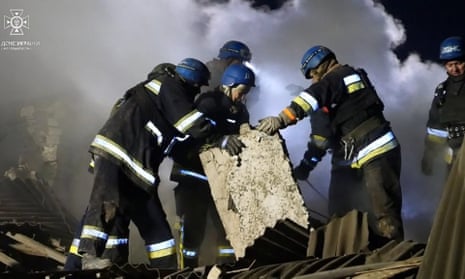 Rescuers moving concrete blocks at the site of a maternity ward destroyed by shelling in Vilniansk, Zaporizhzhia region.