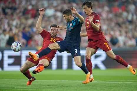 Croatia's Andrej Kramaric, centre, is challenged by Spain's Aymeric Laporte.