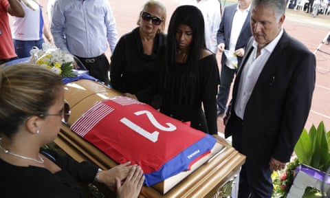 Family members place a Panama jersey over the coffin of Amílcar Henriquez, who was murdered outside his home, during his funeral in Nuevo Colón.