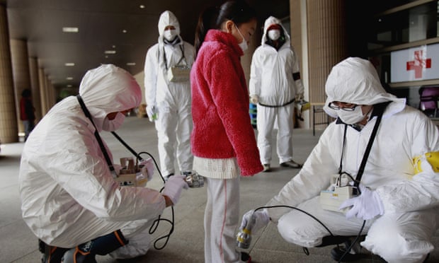 An evacuee is checked for radiation in Japan after Fukushima