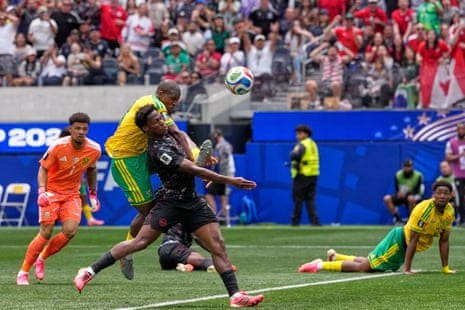 South Africa’s Mbekezeli Mbokazi and Canada’s Jonathan David vie desperately for the ball.