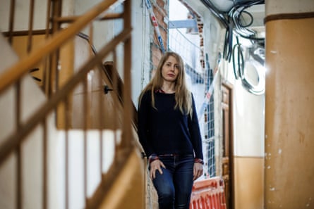 Cristina Gómez poses in the stairwell beside a hole in the wall